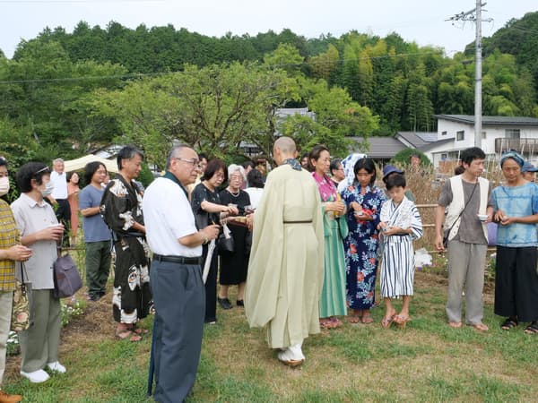 Attendees scattering cosmos and clover seeds around the grounds