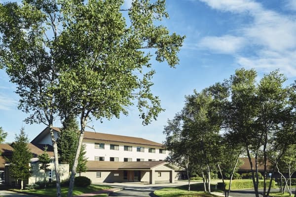 Entrada del hotel entre vegetación fresca a principios de verano
