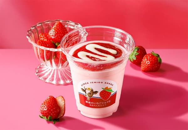 Ginza Strawberry Shake with Morinaga Condensed Milk disajikan dalam gelas bening, dengan buah stroberi segar di sampingnya