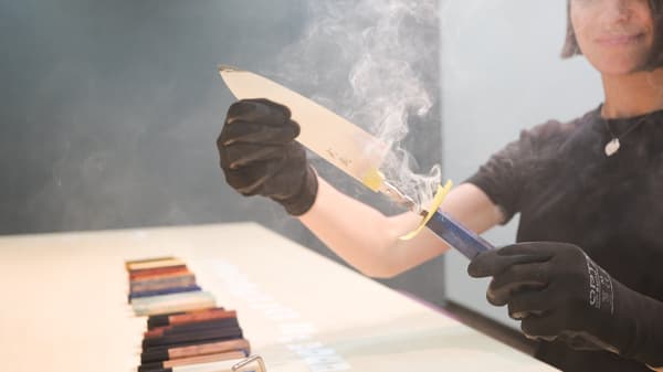 Visitors work with an instructor to shape their own knife by hand