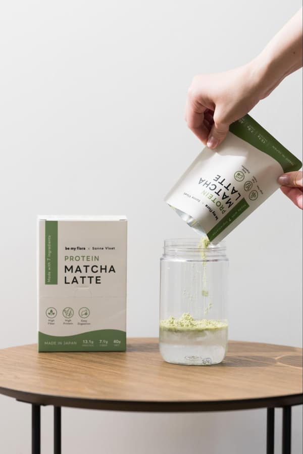 Menuangkan bubuk PROTEIN MATCHA LATTE ke dalam botol pengocok