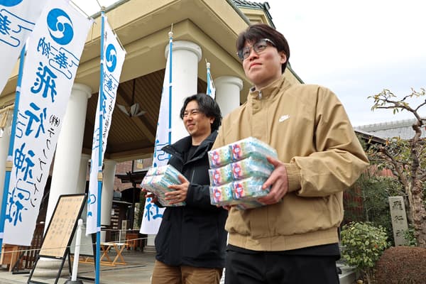 工作人员带着御守祈福