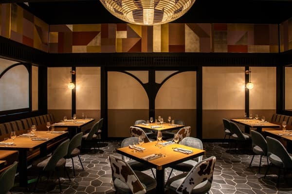 Dining room at KŌSA with patterned wall panels and a pendant light