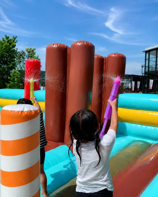 Kids enjoying the inflatable water attraction at WHATAWON