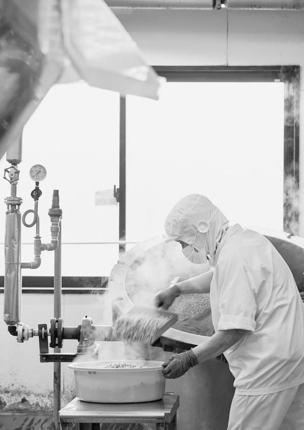A worker handling beans during natto production