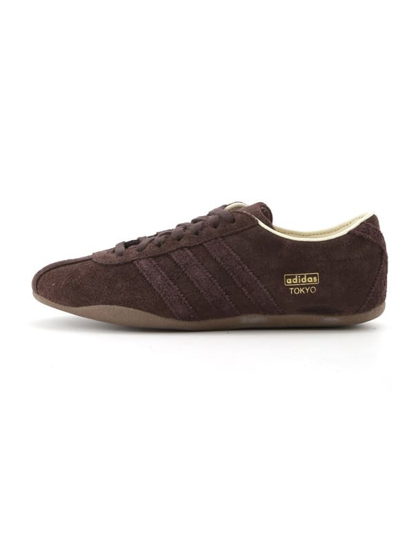 Tampilan detail siluet ramping dan logo emas sepatu kets TOKYO W EMMI