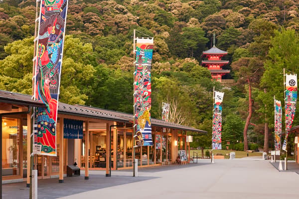 Tiendas en el Parque Gifu al pie del monte Kinka, con pancartas y una pagoda de tres pisos en la ladera