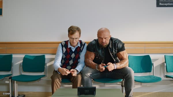 Two people playing the game while waiting in a reception area