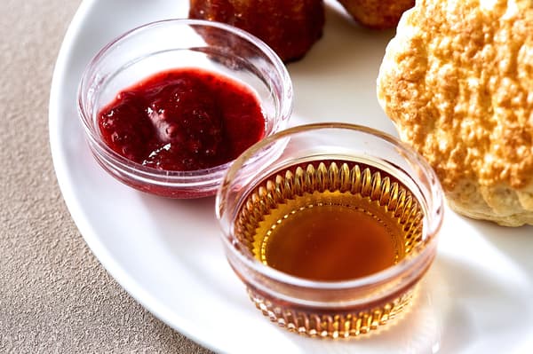 Scone accompaniments — strawberry jam and maple syrup