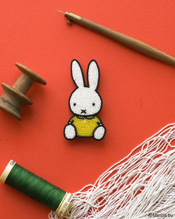 Broche Miffy mf-b002 sobre una superficie con herramientas de bordado