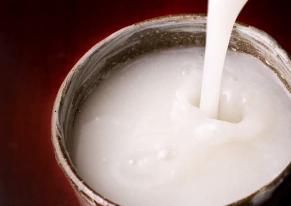Nigori sake being poured into a cup