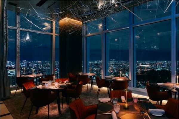 Interior del restaurante en KEI Collection PARIS con vistas nocturnas de la ciudad