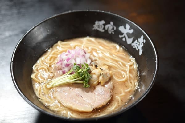 一碗以蛤蜊、叉燒和紫洋蔥碎為配料的鹽味豚骨拉麵