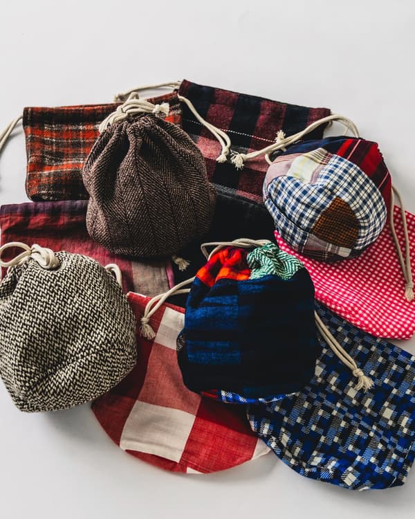 Un grupo de bolsitas con cordón en telas de cuadros, tweed y patchwork
