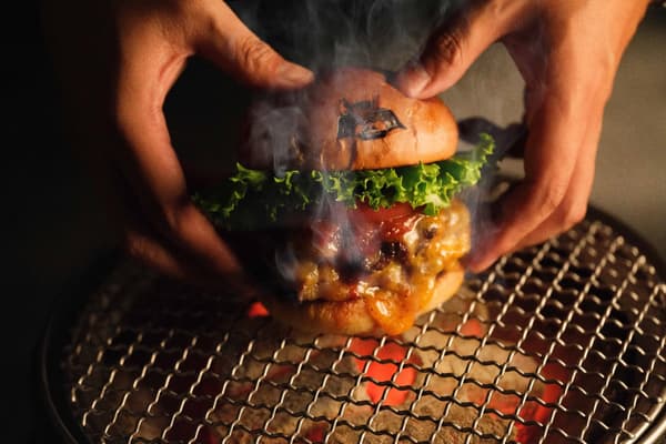 Hamburguesa de SHOGUN BURGER sobre una parrilla de carbón