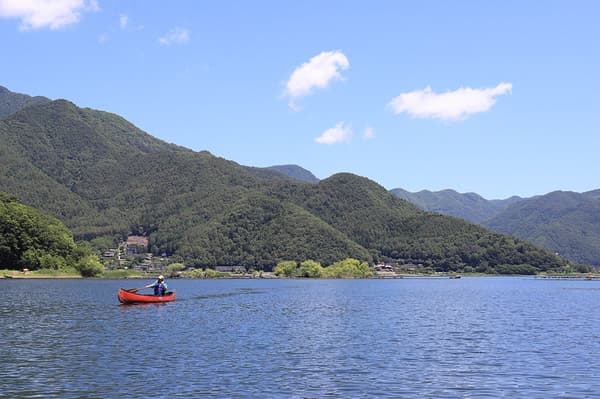 从湖面望向河口湖北岸的山峦与城镇风光