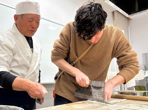 Un maestro soba guía a un visitante extranjero a través del proceso de elaboración del soba