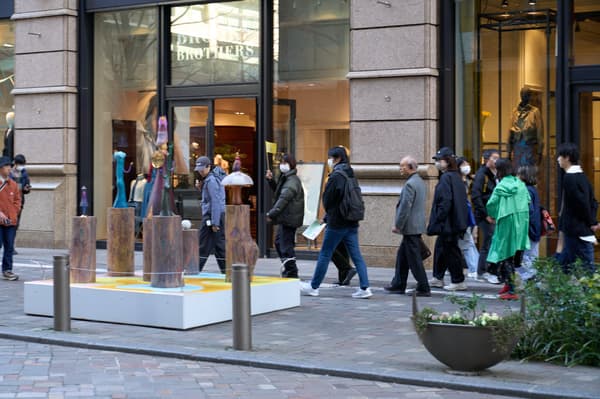 Outdoor artwork on a city street with pedestrians passing by