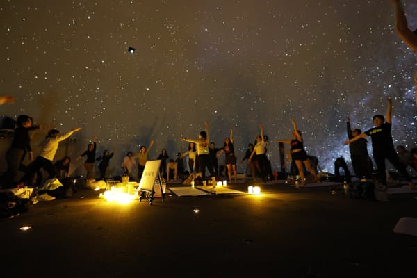 Participants enjoying yoga under the planetarium's starry sky