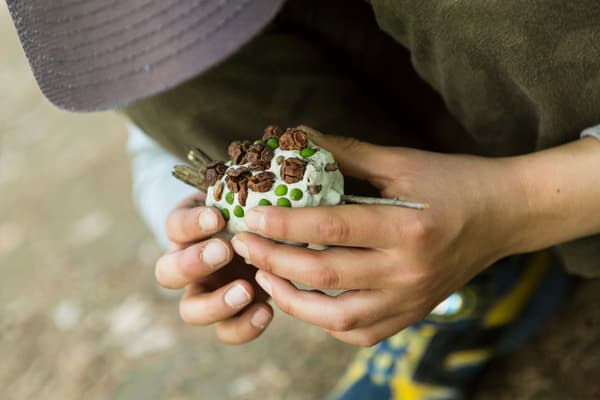 Hands holding a small clay creature
