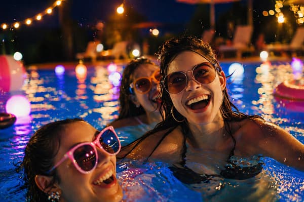 An adults-oriented night pool with a view of the night skyline (image)