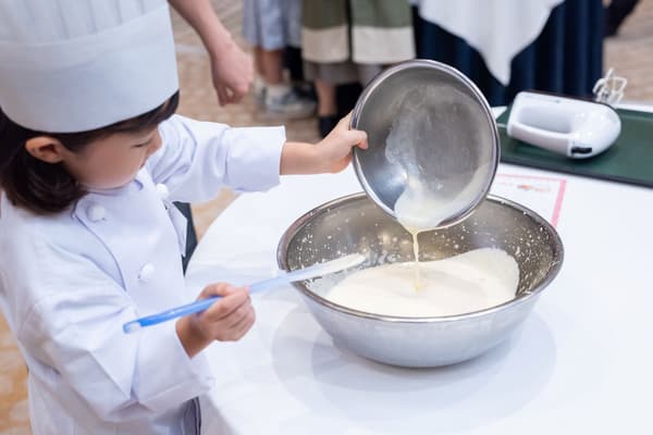 Children experiencing cake decoration at a professional pastry class