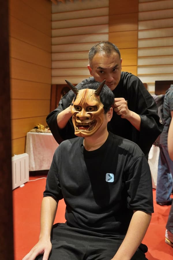 가면 체험 부스에서 노 가면을 써보는 관람객
