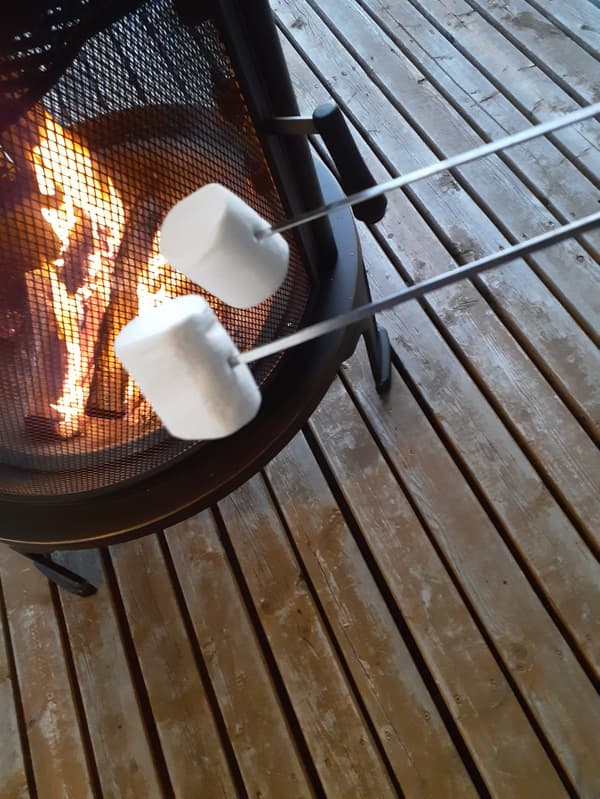 Toasting marshmallows at the outdoor fireplace on the wood deck