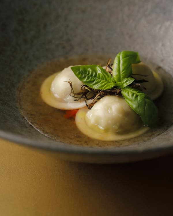 Ravioli filled with fried eggplant and Tamba milk ricotta, served in a Kamigamo tomato consommé