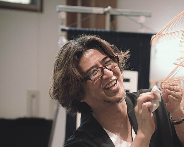 Un artesano sonriente trabajando con tiras de bambú