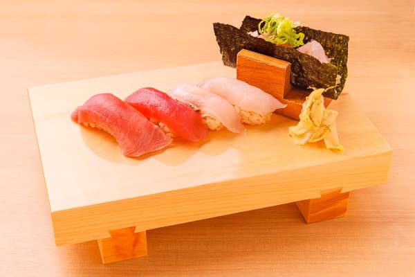 Aneka nigiri cuka merah di atas papan saji kayu