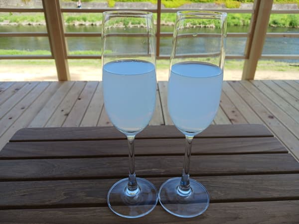 Sake japonés espumoso servido como bebida de bienvenida en la terraza