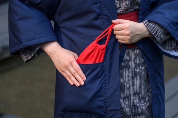賓客將溫熱的溫石放入棉襖口袋中