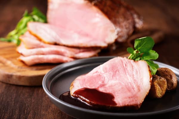 在餐桌旁切釉面烤猪肉