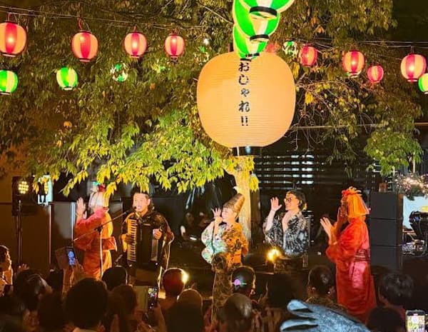 Artistas en el escenario bajo farolillos de papel en un Oshare Bon Odori pasado