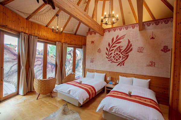 Tempat tidur twin di kamar yang didekorasi dengan motif Monster Hunter