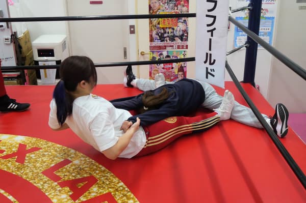 Belajar gerakan pro wrestling dengan pelatih yang mendampingi