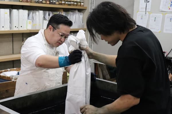 El gerente de la tienda probando el teñido con añil