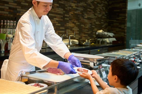 现场烤牛肉切片，孩子们兴奋地看着