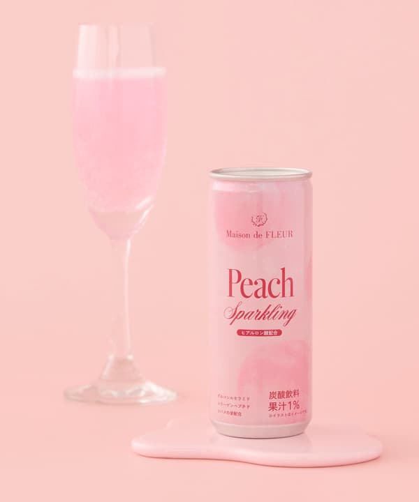 Lata de Peach Sparkling de Maison de FLEUR junto a un vaso de la bebida rosa
