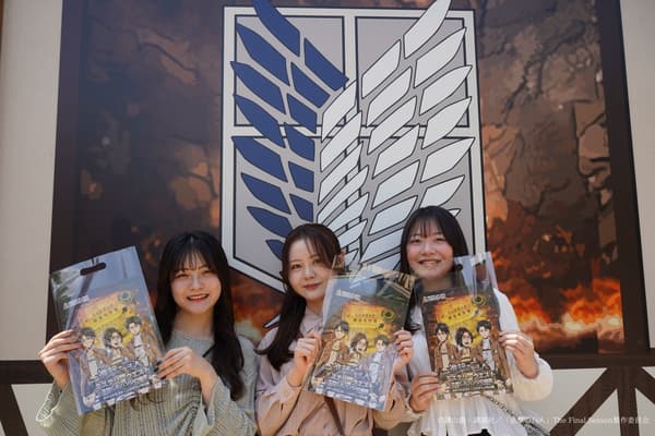 遊客在調查兵團紋章前拿著進擊的巨人解謎遊戲物品