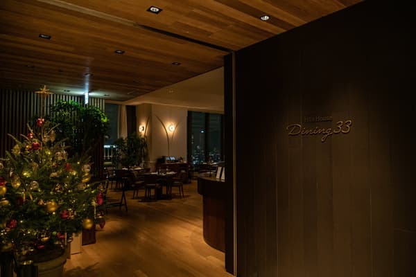 Entrada de Dining 33 con un árbol de Navidad y el comedor al fondo
