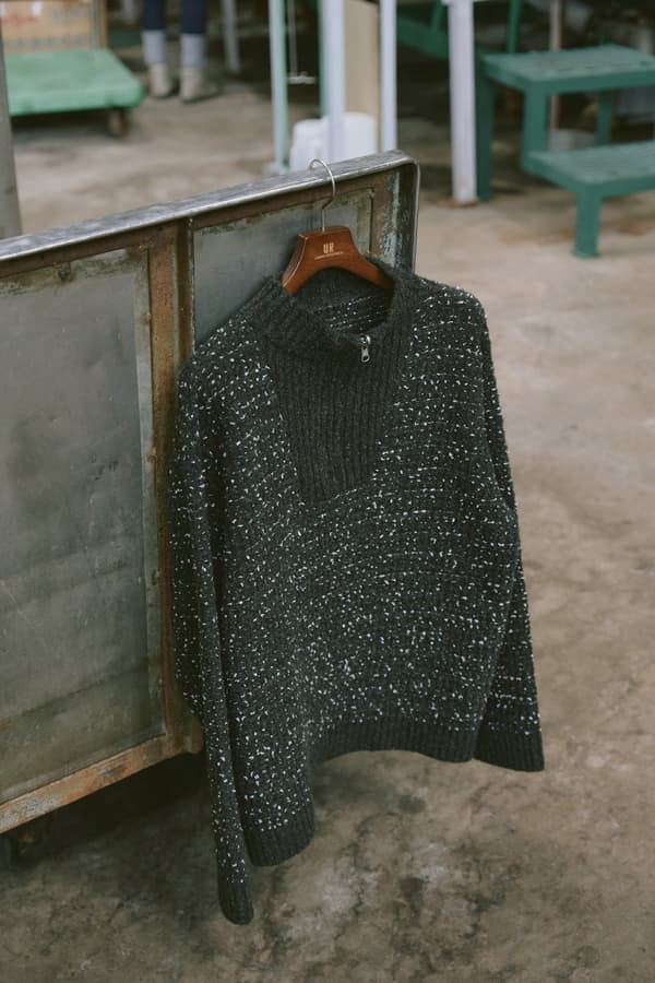 Jersey de punto de tweed de fantasía con media cremallera en una percha