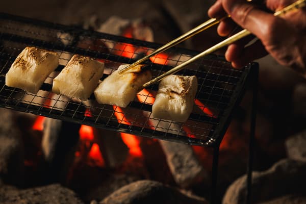Mochi persegi yang kecokelatan di atas arang