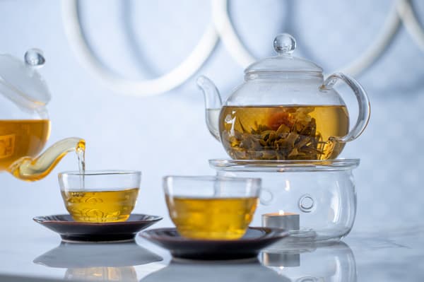 Tea poured from a glass teapot into glass cups