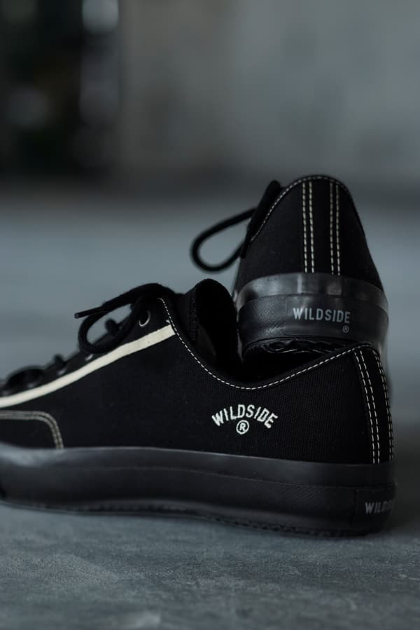 Primer plano del logotipo bordado de WILDSIDE en el talón de las zapatillas negras