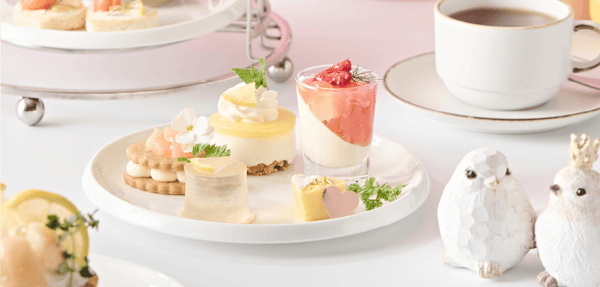 A plate of five mini sweets in pale pink and vivid yellow, evoking the flutter of first love