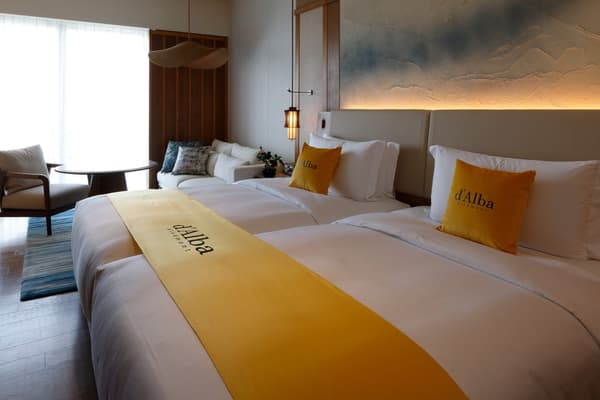 Habitación con camino de cama y cojines en amarillo d'Alba