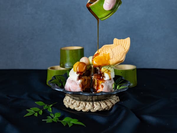 Menuangkan saus kuromitsu di atas MOCHI MELT