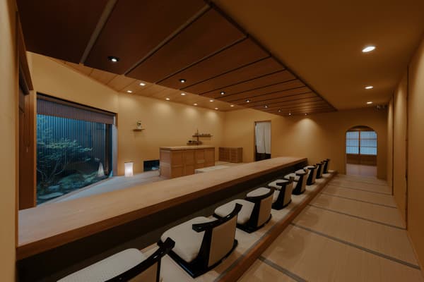 Interior かにじぇんぬ 金沢, dengan delapan kursi konter yang diatur dengan jarak yang luas di antaranya.
